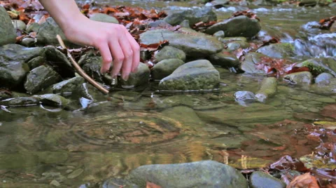 Girl's hand throwing a pebble in the brook 스톡 동영상 45429960