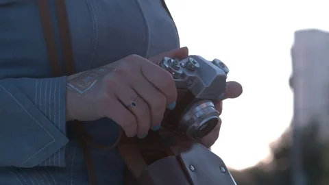 Girl's hands hold the vintage old film camera. Girl camera shutter clicks close Stock Footage