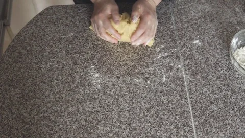 Girl's hands kneading dough in flour on table Stock Footage