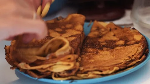 Girl's hands stack baked pancake on a plate Stock Footage 112018001