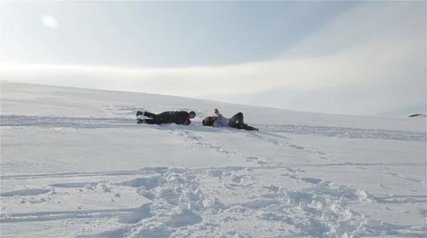 Girls having fun rolling down snowy mountain Stock Footage 39691922