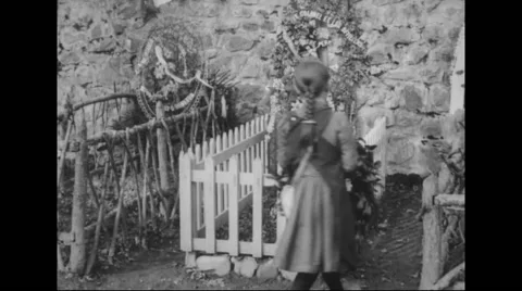 Girls laying wreath and bouquet on grave Stock Footage