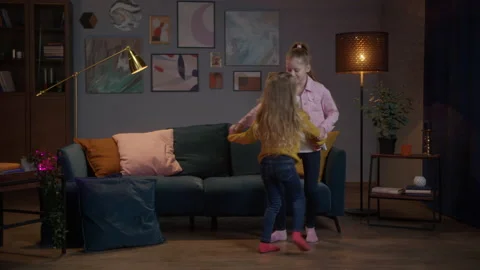 Girls learn dancing in room apartment at evening and watching tv , sister makes Stock Footage 150439717