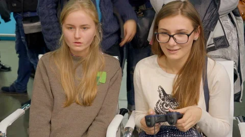 Girls Playing Console. They Sit Side by Side and Looking at the Monitor Stock Footage 68384995