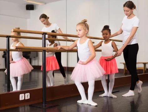 Girls practicing elements on ballet barre Stock Photos