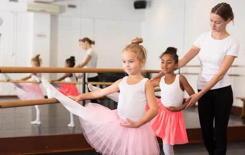 Girls practicing elements on ballet barre Foto stock
