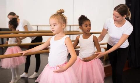 Girls practicing elements on ballet barre Stock Photos