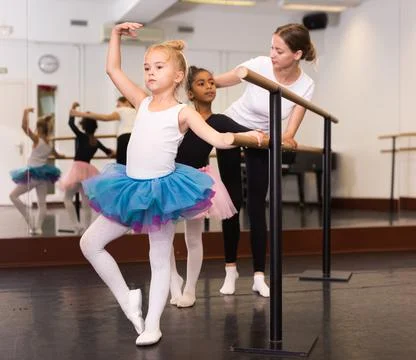 Girls practicing elements on ballet barre Stock Photos