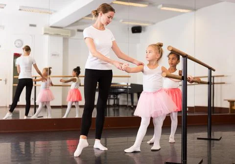 Girls practicing elements on ballet barre Stock Photos