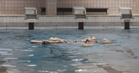Girls practicing in the pool and their legs above water Stock Footage 282995794