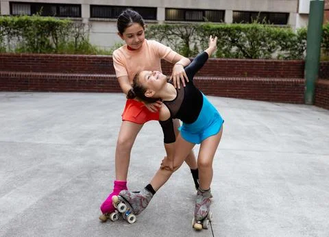 Girls practicing roller skating pose in the park, copy space. Foto stock