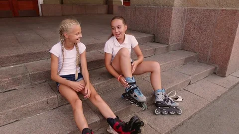 Girls put on rollers in the city square Stockbeeldmateriaal 80345148
