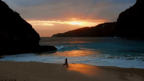 Girls run at beautiful sunset near the ocean in Kelingking beach Stock Footage