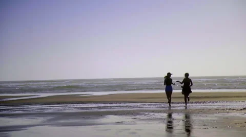 Girls run down beach Stock Footage 52556410