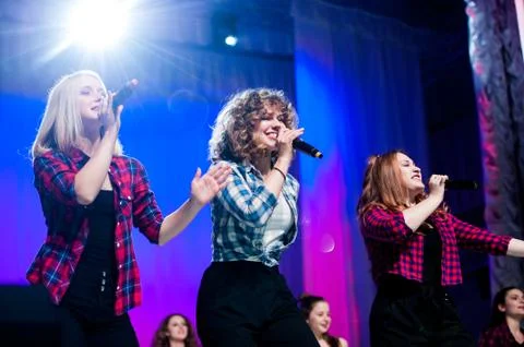 Girls singing on concert stage Stock Photos