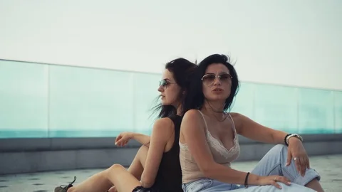 Girls sit back to back 4k Stock Footage 113056475