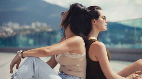 Girls sit back to back Stock Footage 113056400