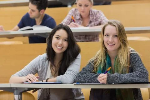 Girls smiling in lecture hall with tablet pc Stock Photos