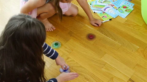 Girls spin multi-colored spinners on the floor Stock Footage 106009330