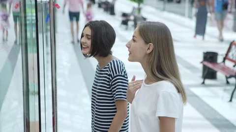 Girls standing before window display Stock Footage 97997490