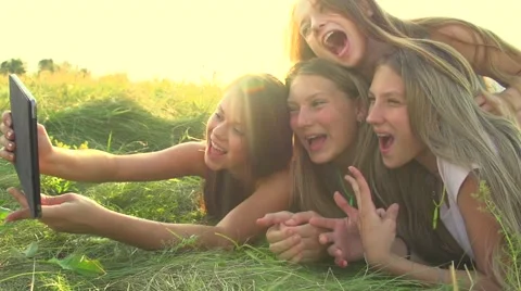 Girls with a touchscreen tablet lying on the grass Stock-Footage 50067776