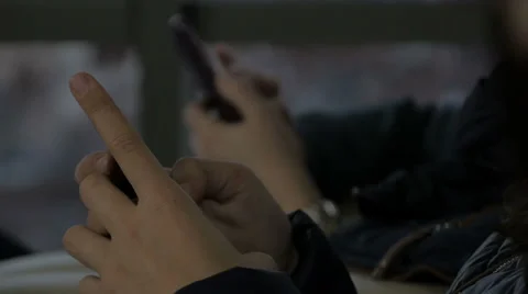 Girls typing message on mobile, changing focus from foreground to background. Stock Footage 59545905