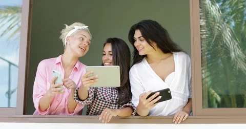 Girls Use Cell Smart Phones And Tablet Take Photo Standing At Window Sill Stock Footage