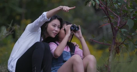 Girls Using Binoculars Viewing Birds in Garden Stock Footage 116548246