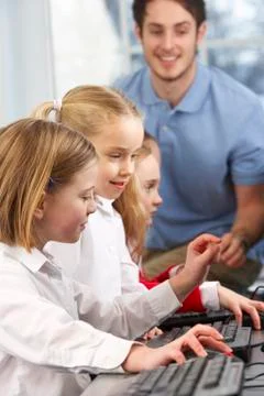Girls using computers in class with teacher Stock Photos
