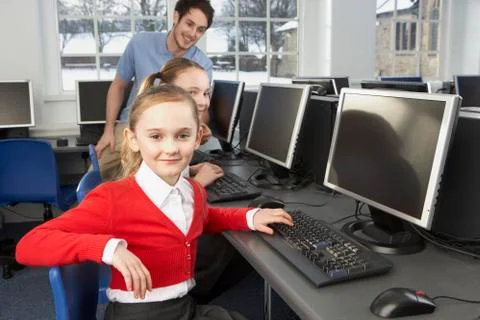 Girls using computers in school class Stock Photos