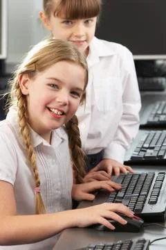 Girls using computers in school class Stock Photos