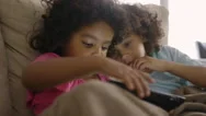 Girls Using Digital Tablet On Sofa Stock Footage