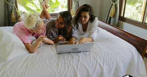 Girls Using Laptop Computer Lying On Bed Laugh Talking, Young Women Group Video stock 75210214