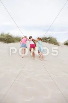 Girls Walking Up A Sand Dune