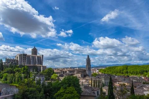 Girona old town view with green mountains and blue sky with clouds Stock Photos