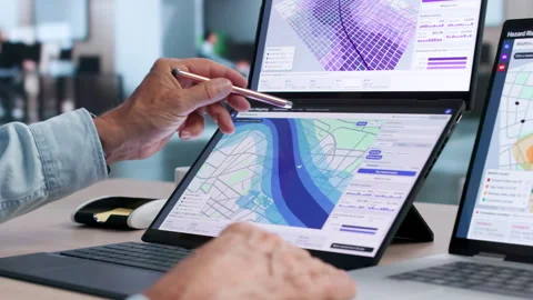 GIS Analyst Studies Flood Risk Map On Dual Touchscreen Laptop Stock Footage 344711564