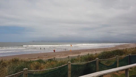 Gisborne beach, life saving flags set up for rip tides and surfers safey Stock Footage 101049918