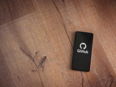GitHub app launch screen with logo on the display of a black mobile smartphon Stock Photos