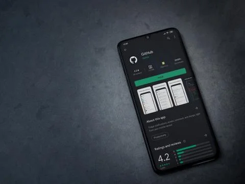 GitHub app play store page on the display of a black mobile smartphone on dar Foto stock