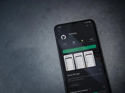GitHub app play store page on the display of a black mobile smartphone on dar Foto stock