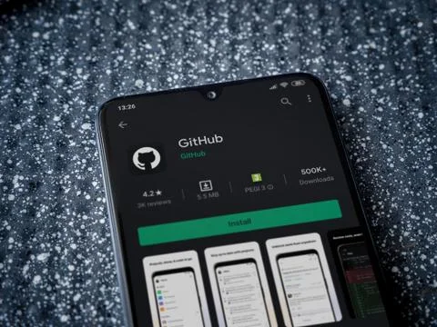 GitHub app play store page on the display of a black mobile smartphone on a m Foto stock