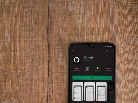 GitHub app play store page on the display of a black mobile smartphone on woo Foto stock