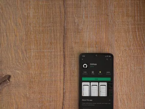 GitHub app play store page on the display of a black mobile smartphone on woo Foto stock