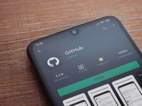 GitHub app play store page on the display of a black mobile smartphone on woo Foto stock