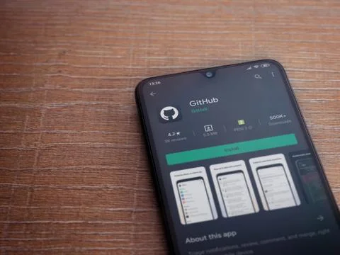GitHub app play store page on the display of a black mobile smartphone on woo Foto stock