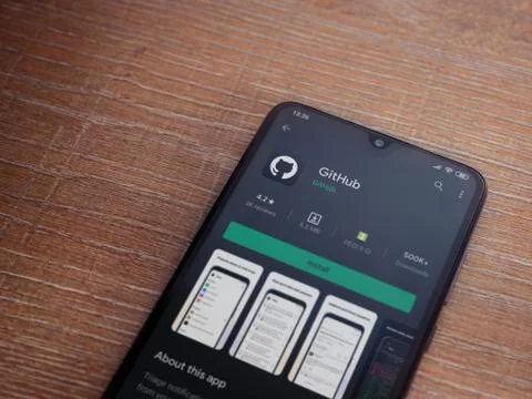 GitHub app play store page on the display of a black mobile smartphone on woo Stock Photos