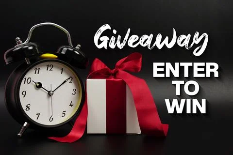 Giveaway Enter To Win text with gift box present and alarm clock on black b.. Stock Photos