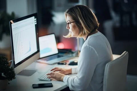 Giving her work commitments her all. a businesswoman using a computer during a Stock Photos