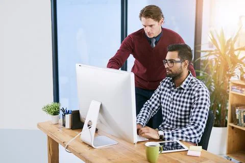 Giving him some pointers. creative businesspeople working in the office. Stock Photos