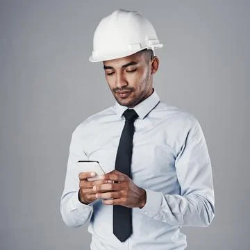 Giving his team the go-ahead. a well-dressed civil engineer using his cellphone Stock Photos